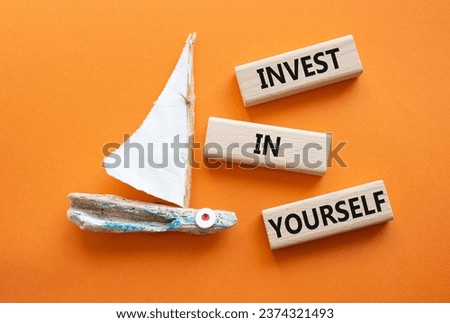 Invest in Yourself symbol. Concept words Invest in Yourself on wooden blocks. Beautiful orange background with boat. Business and Invest in Yourself concept. Copy space.