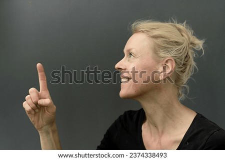 woman pointing his finger with dark background with people stock image stock photo