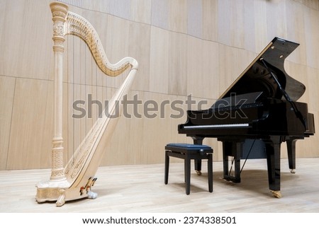 A harp and a piano stand side by side in a bright hall