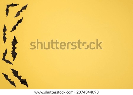 Yellow background with bats in the lower left corner. copy space. Halloween