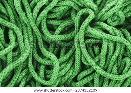 Rope texture. Green color rope messy background. Random shape pile of rope. Spiral loop. Abstract textile pattern. Green cotton rope background.