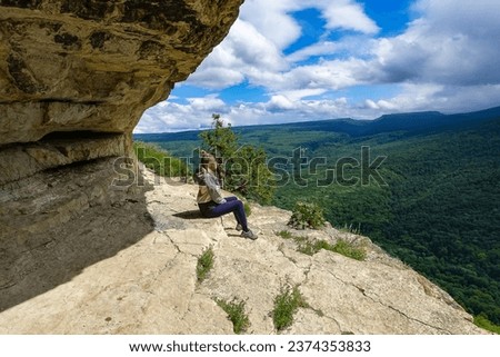 A girl on the background of the landscape of the Caucasus Mountains - The Eagle Rocks Mountain shelf, Mezmai