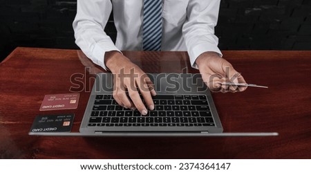 Young Asian consumer businessmen hand holding mock-up credit card, Ready to spending pay online shopping according to discount products via laptop from home office.