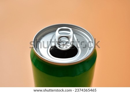aluminum green drink cans on orange background, open cold fresh beverage Royalty-Free Stock Photo #2374365465