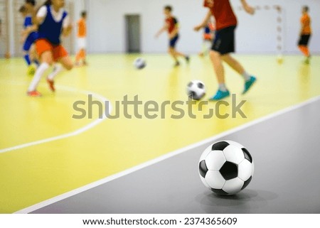Indoor soccer training class for children. Soccer skills training. Futsal players in practice game at sports hall Royalty-Free Stock Photo #2374365609