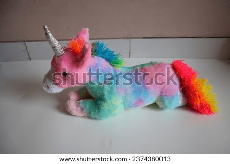 A unicorn doll placed on a white background.