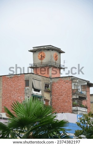 Brick house with clock tower and balconies, city view of the old town of Shkodra in Albania