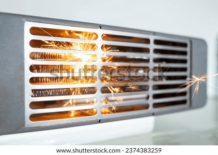 Electric fan heater exploding with sparks, domestic short circuit concept Royalty-Free Stock Photo #2374383259