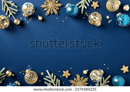 Christmas frame of blue and gold luxury Xmas balls ornaments, fir branches, confetti on dark blue background. Happy New Year greeting card template, banner mockup. Flat lay, top view, copy space.