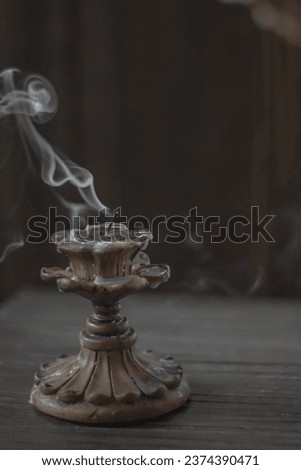 Isolated candle on black with vintage retro candle holder emitting a smoke Royalty-Free Stock Photo #2374390471