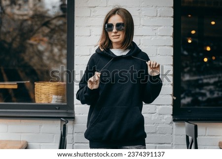Young woman in glasses and black hoodie Royalty-Free Stock Photo #2374391137