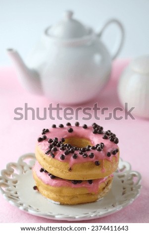 Morning coffee and pink glaze doughnut on a pink background
