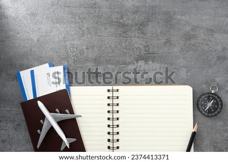 Passport with boarding pass and note book on stone texture background. Tourism and travel concept. Top view. Flat lay.