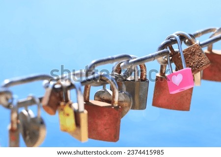 Love, romantic. Old rusty love locks on chain against background of blue sea on sunny day. Valentine day love symbol concept. Locked locks of love and loyalty. Greeting card 