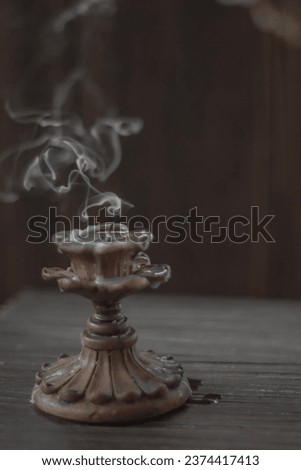Isolated candle on black with vintage retro candle holder emitting a smoke Royalty-Free Stock Photo #2374417413