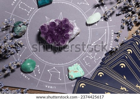 Astrology prediction. Zodiac wheel, gemstones, tarot cards and lavender on wooden table, flat lay