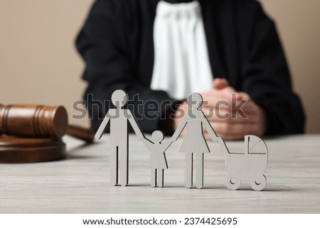 Family law. Judge with gavel sitting at white wooden table, focus on figure of parents and children Royalty-Free Stock Photo #2374425695