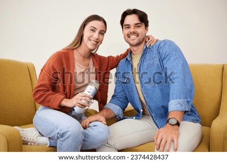 Portrait, microphone and podcast with a couple on a sofa in the living room of their home together. Smile, radio or talkshow with a happy young man and woman in their house for live streaming