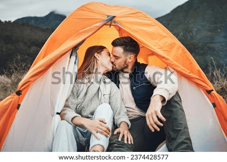Couple, kiss and tent in camping on mountain for love, care or affection in nature together. Woman kissing man on camp site for romantic getaway, holiday vacation or weekend in outdoor bonding Royalty-Free Stock Photo #2374428577