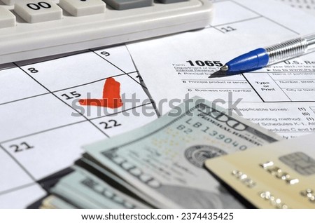 1065 Return of partnership income blank with dollar bills, calculator and pen on calendar page with marked 15th April. Tax period concept. IRS Internal Revenue Service Royalty-Free Stock Photo #2374435425