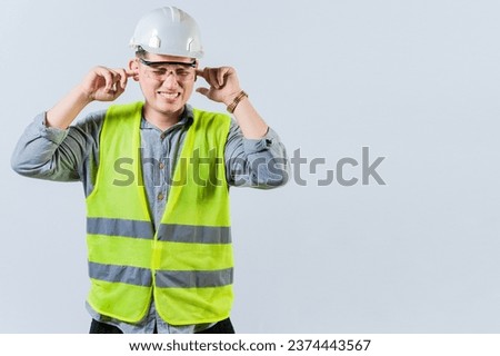 Young engineer covering ears isolated. Engineer man with ear pain. Concept of engineer covering his ears with pain expression Royalty-Free Stock Photo #2374443567
