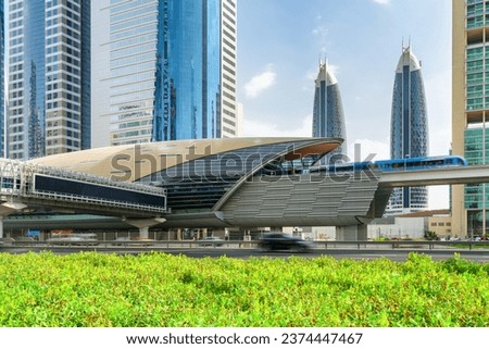 Awesome view of train of the Dubai Metro arriving to Financial Centre Station at downtown of Dubai, United Arab Emirates (UAE). Amazing skyscrapers are visible on blue sky background. Scenic cityscape Royalty-Free Stock Photo #2374447467