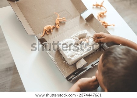 An interesting activity for children: excavating dinosaurs,. Royalty-Free Stock Photo #2374447661
