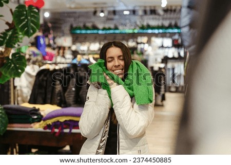Cute happy young woman in a fashionable warm wool scarf . Sopping concept.