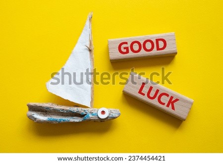 Good luck symbol. Wooden blocks with words Good luck. Beautiful yellow background with boat. Business and Good luck concept. Copy space.
