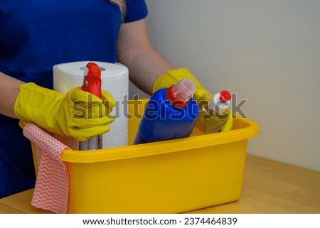 The cleaning lady places cleaning products in a container