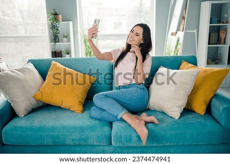 Full length photo of peaceful lovely person sit comfy couch hold telephone take selfie house indoors