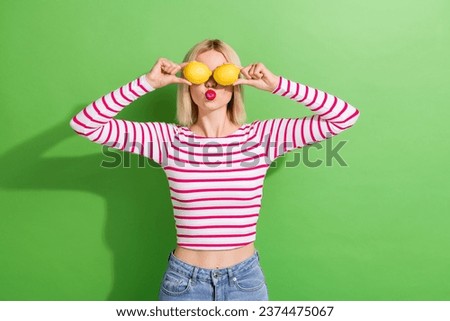 Photo of pretty young girl have fun hold two fresh fruits lemons blow air summer face skincare detox isolated on green color background