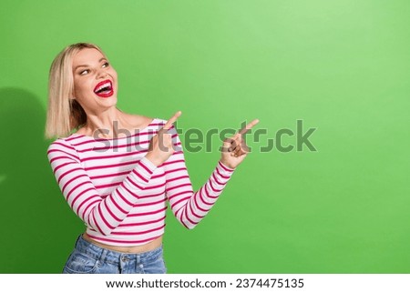 Photo of ecstatic woman with bob hairdo dressed striped shirt look directing at empty space offer isolated on green color background