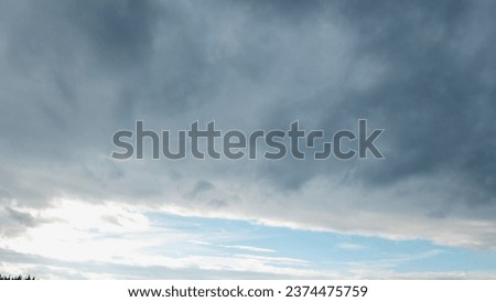 Autumn brings overcast skies adorned with gray stratus clouds, hinting at impending rain. This full-screen view provides ample space for text or design elements, making it perfect for various projects Royalty-Free Stock Photo #2374475759