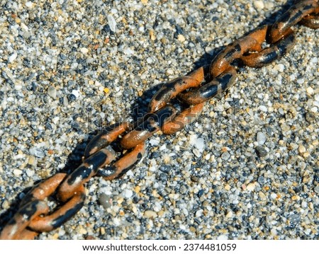 Natural background of many little coast pebble stones and rusty metal anchor chain , horizontal picture