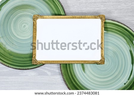 golden picture or photo frame mockup above swirl shape plate on gray wood table