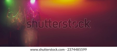 Friends meeting. Youth culture. Vising concert. Group of young, active people at the night club, party dancing in neon lights. Concept of party, fun, holiday, relaxation, meeting Copy space for ad