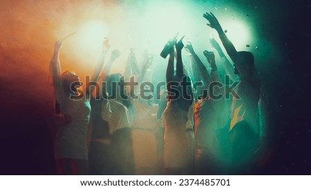 Music. Youth culture, night lifestyle. Vising concert. Group of young, active people at the night club, party dancing in neon lights. Concept of party, holiday, relaxation, meeting Copy space for ad