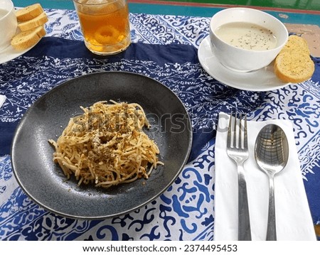 Spaghetti alla puttanesca - italian pasta dish with tomatoes, black olives, capers, anchovies and basil