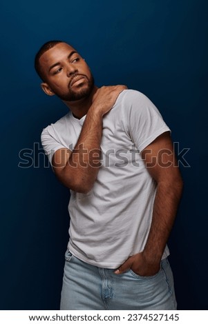 young african american in white shirt and jeans gesturing and looking away, fashion concept Royalty-Free Stock Photo #2374527145
