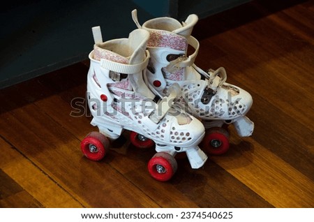 Roller shoes for little girls on wooden floor