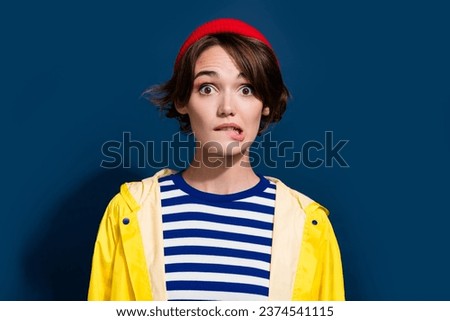 Portrait photo of funny biting lips nervous girl anxious forgot outdoors weather forecast today is cold isolated on blue color background Royalty-Free Stock Photo #2374541115