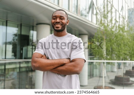 Happy african american man smiling outdoor. Portrait of young happy man on street in city. Cheerful joyful handsome person guy looking at camera. Freedom happiness carefree happy people concept Royalty-Free Stock Photo #2374564665