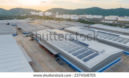 Solar Panels on Warehouse Factory. Solar photo voltaic panels system power or Solar Cell on industrial building roof for producing green ecological electricity. Production of renewable energy.  Royalty-Free Stock Photo #2374568705