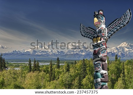 Isolated totem wood pole in mountain blue background Royalty-Free Stock Photo #237457375