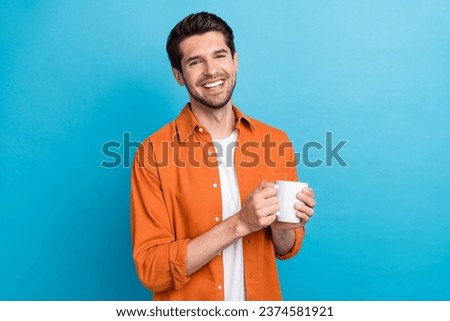 Photo of cheerful good mood man dressed orange shirt enjoying tasty coffee isolated blue color background