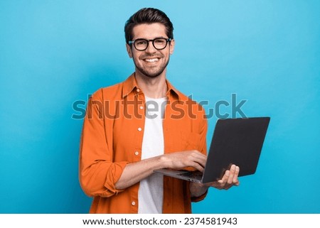 Photo of cheerful corporate agent man toothy smile hold use wireless netbook networking isolated on blue color background Royalty-Free Stock Photo #2374581943