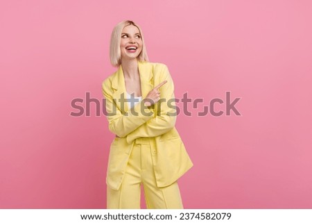 Photo of sweet excited woman dressed blazer suit looking pointing finger empty space isolated pink color background