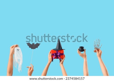 Women with Halloween gift and decor on blue background