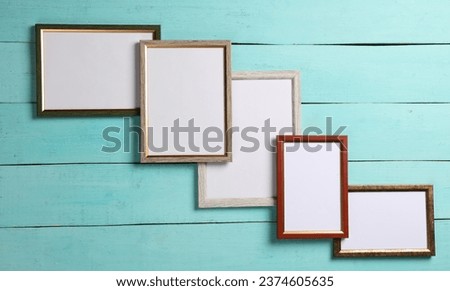 Blank wall frames on blue wooden background